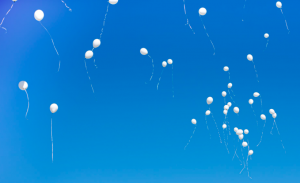 White balloons floating in the sky.